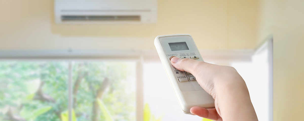 hand holding remote for ductless HVAC wall unit