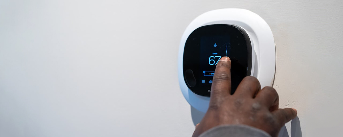 man setting digital thermostat