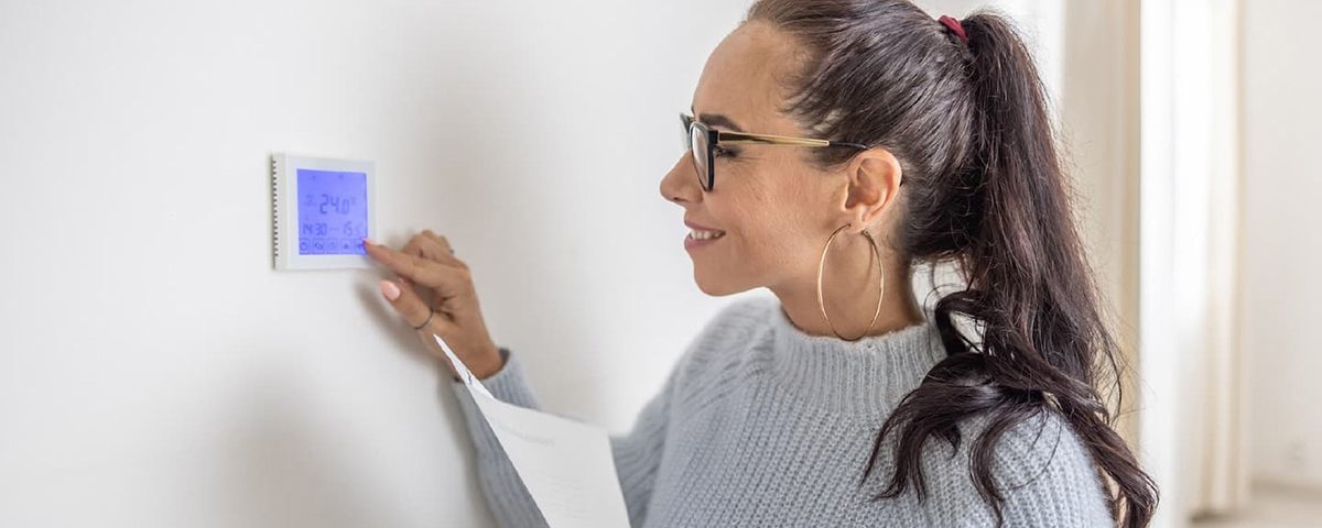 woman setting thermostat